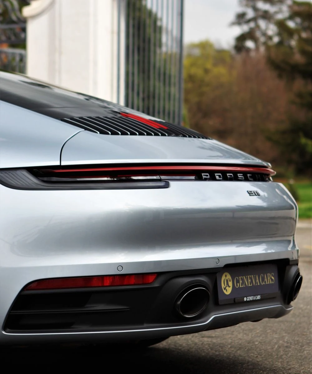 Signature arrière d’une Porsche 911 argentée, plaque Geneva Cars